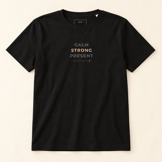 T-shirt preta «Calm. Strong. Present.», vista de frente sobre fundo creme.