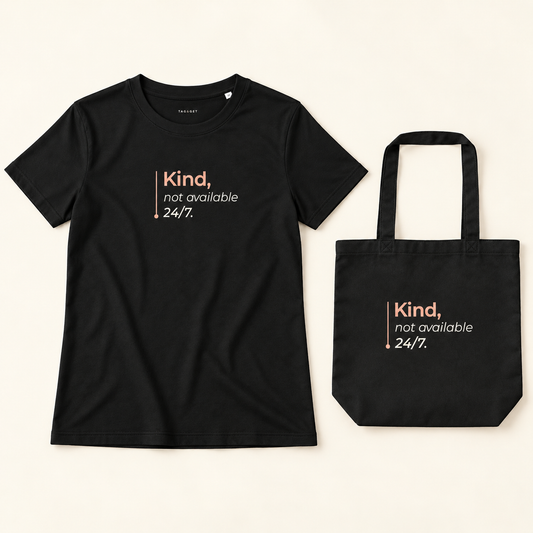 Conjunto de t-shirt e tote bag pretas com a frase “Kind, not available 24/7.”, vistas de frente sobre fundo creme.