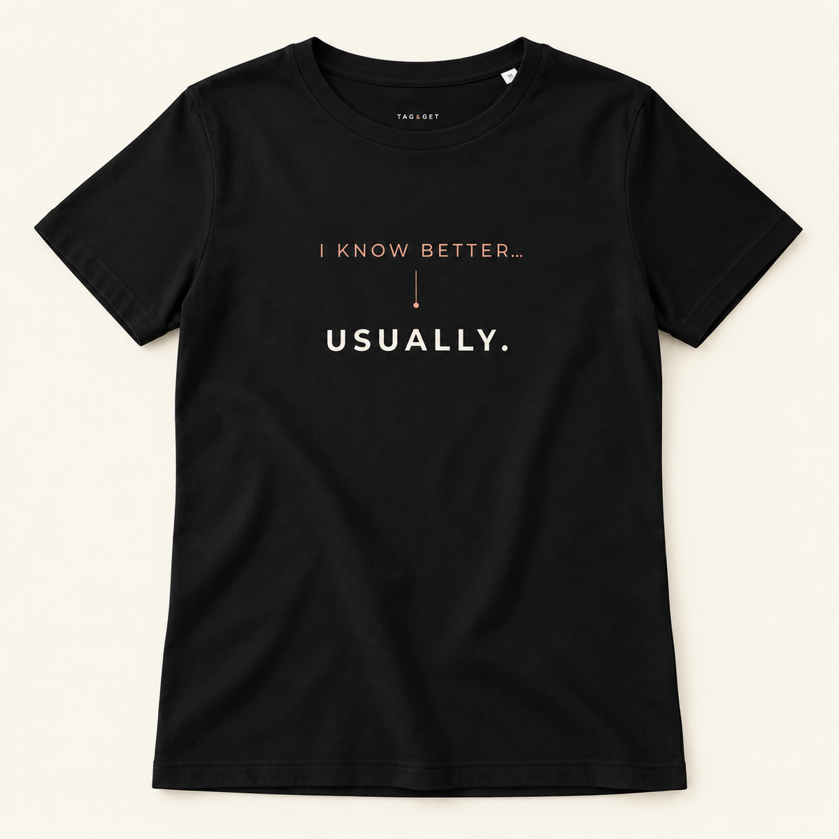 T-shirt preta Tag&Get com a frase “I know better... usually.”, vista de frente sobre fundo creme.