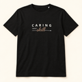 T-shirt preta Caring Takes Skill, vista frontal completa sobre fundo creme.