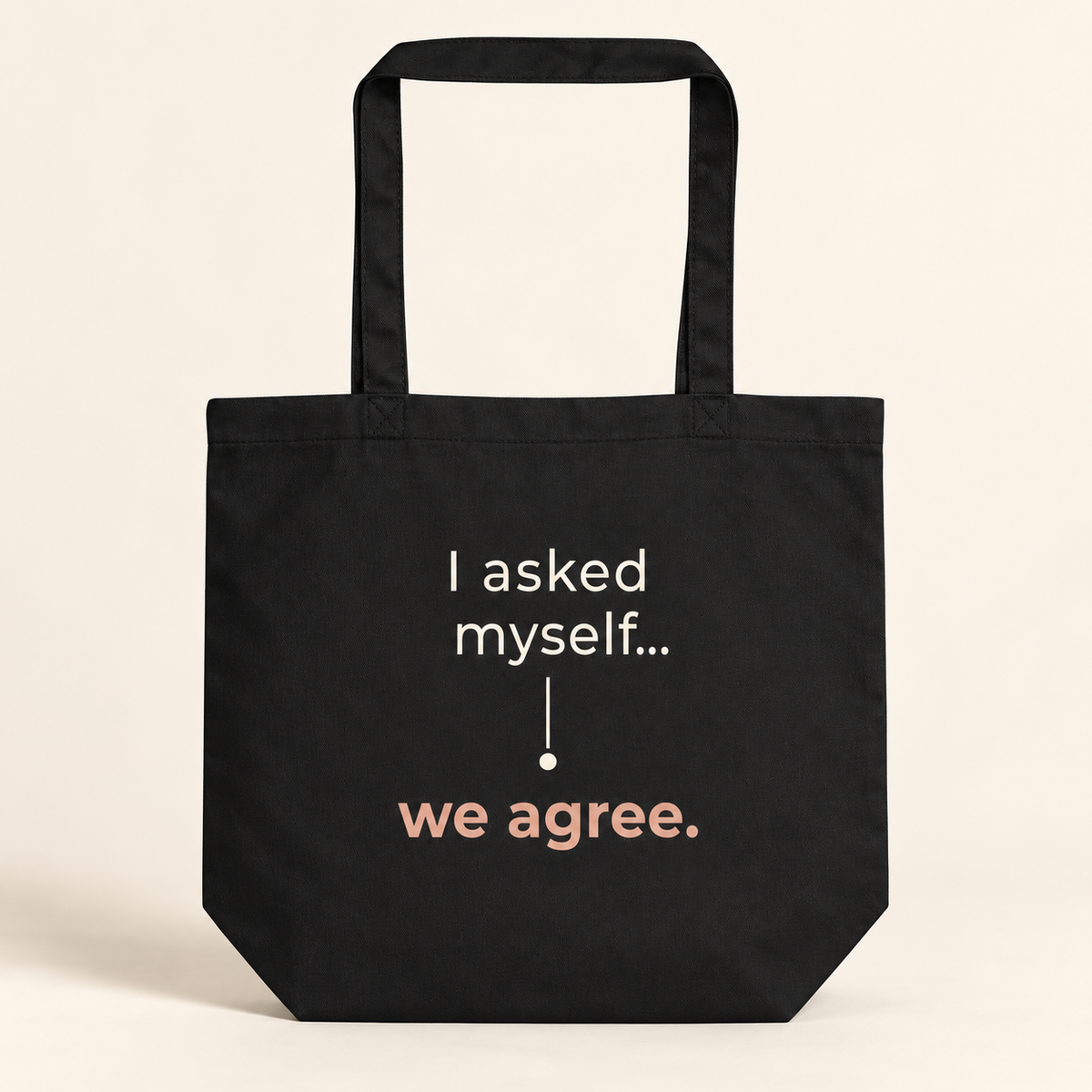 Tote bag preta com a frase “I asked myself... we agree.”, vista de frente sobre fundo creme.