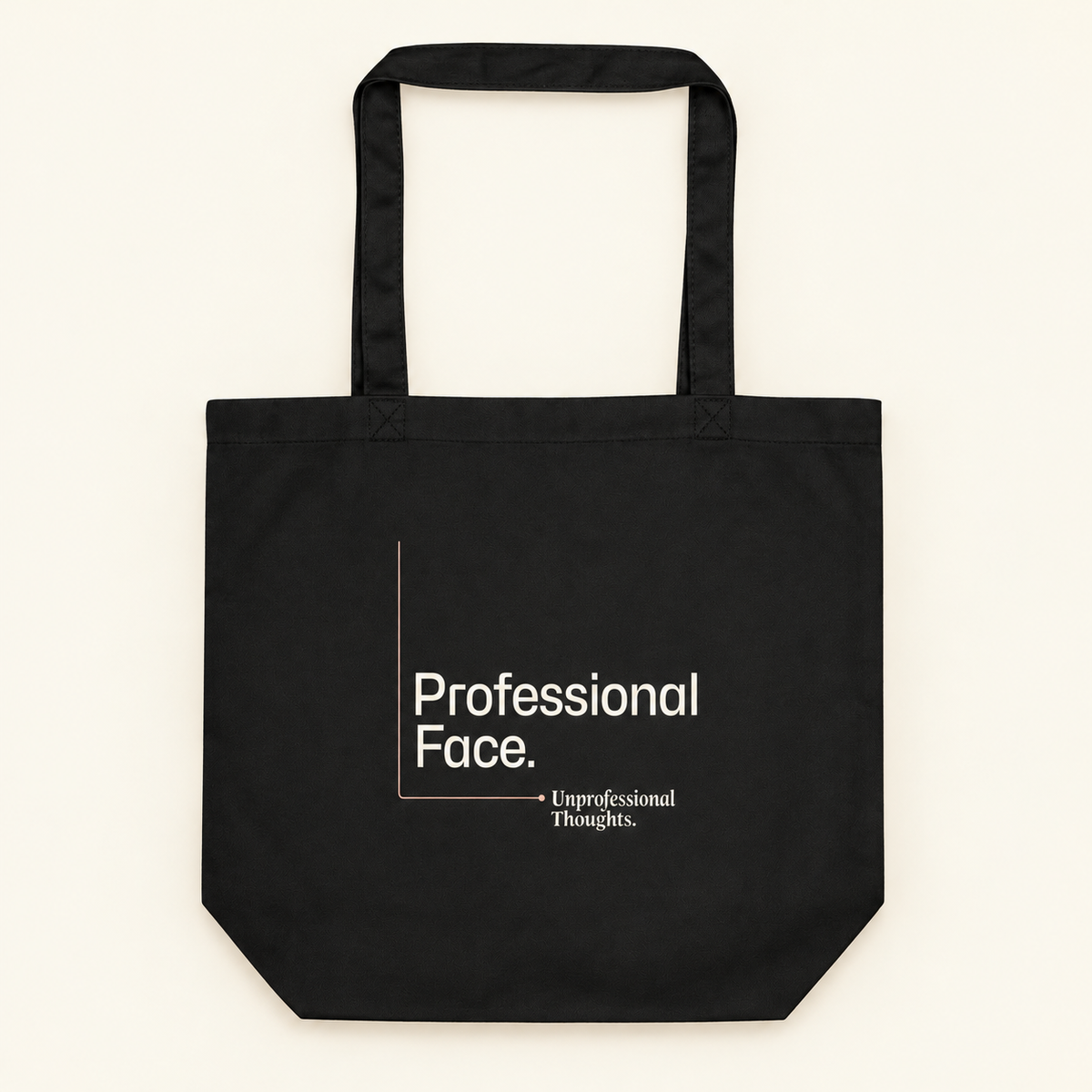 Tote bag preta com a frase “Professional Face. Unprofessional Thoughts.”, vista de frente e completa sobre fundo creme.