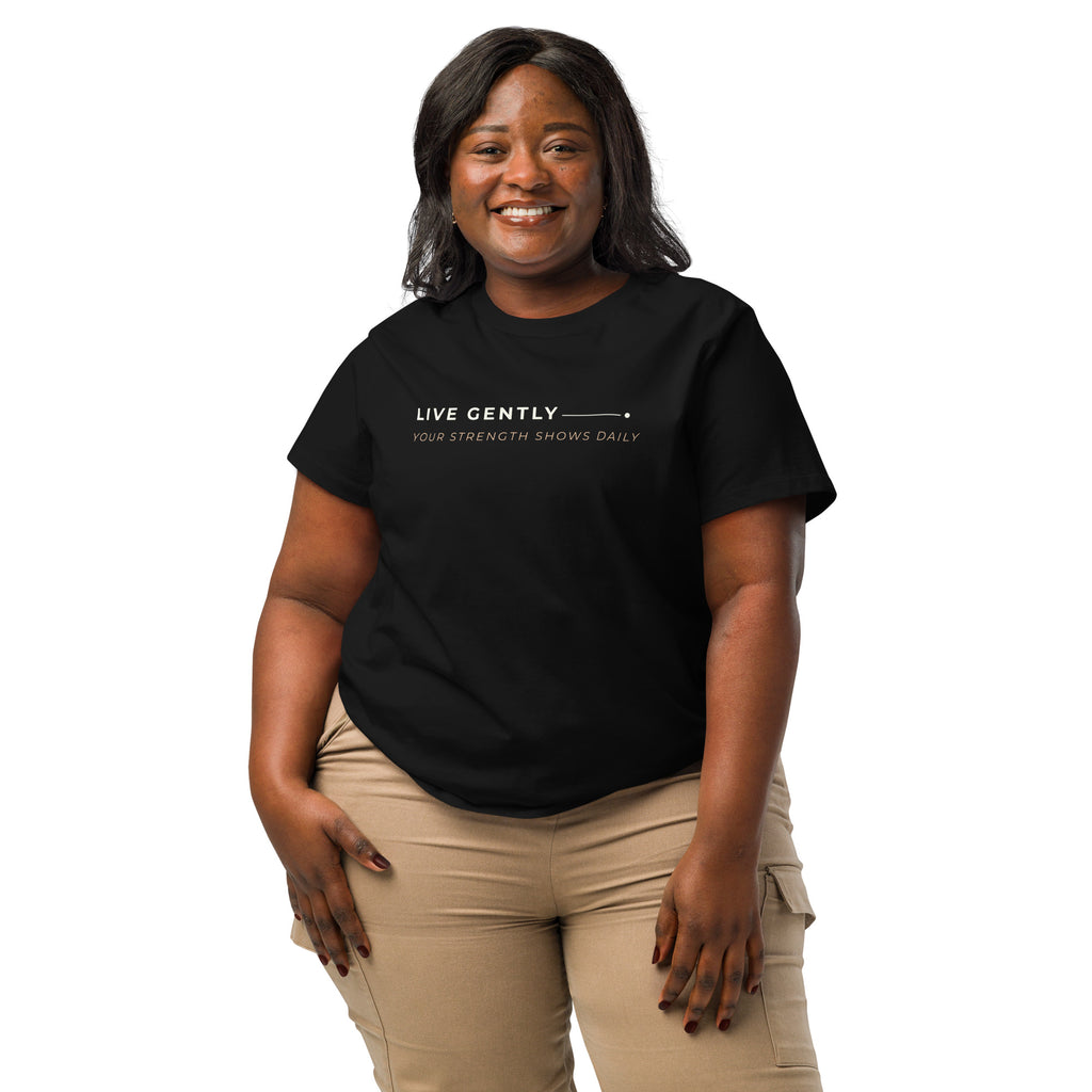 Modelo com T-shirt preta «Live gently, your strength shows daily» e calças bege.
