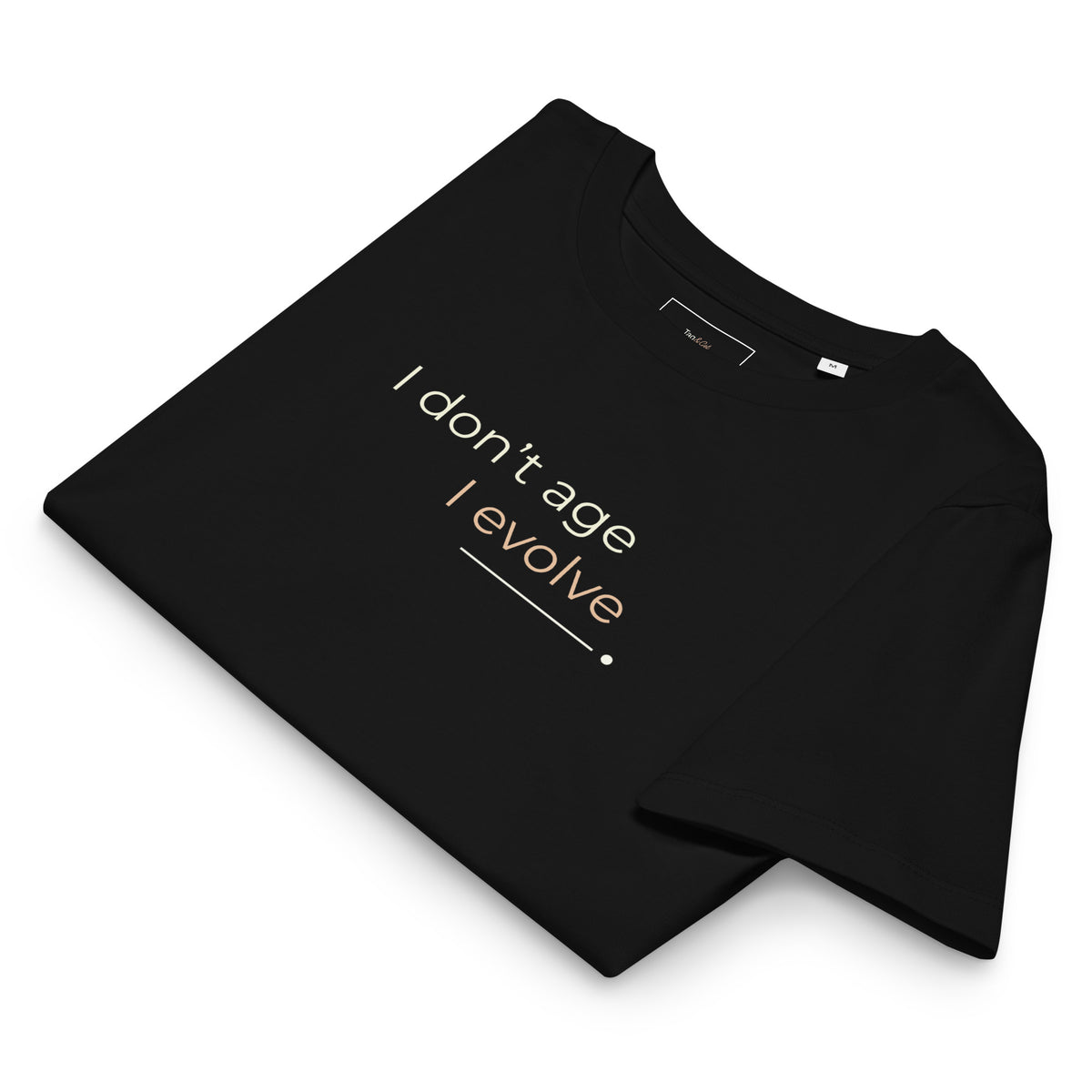 T-shirt preta dobrada com a frase «I don't age, I evolve» visível.
